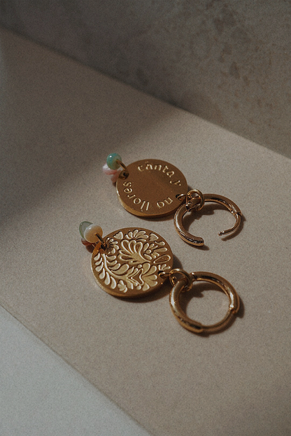 Boucles d'oreilles dorées avec une médaille motifs fleuris et perles multicolores.