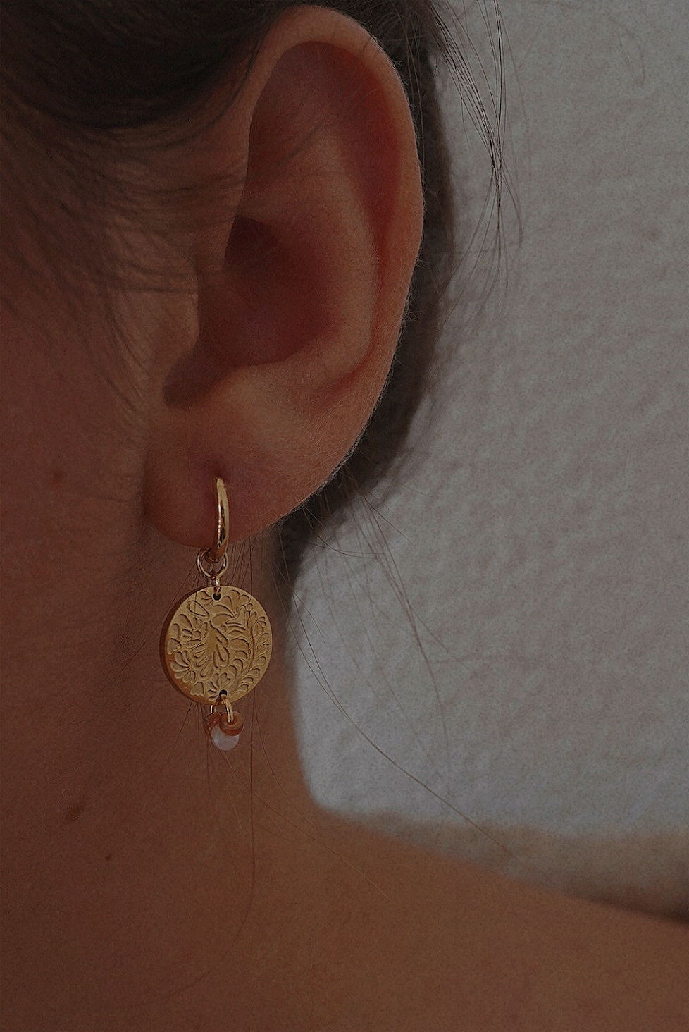 Boucles d'oreilles dorées avec une médaille motifs fleuris et perles marrons.